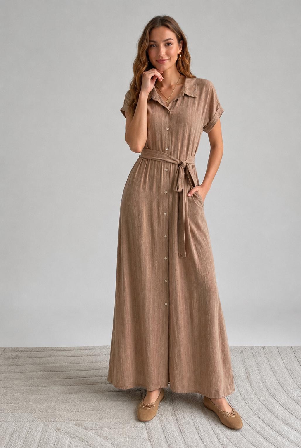 Taupe maxi doorknoopjurk met crinkle structuur, korte mouwen en ceintuur, gemaakt van 85% viscose en 15% nylon.