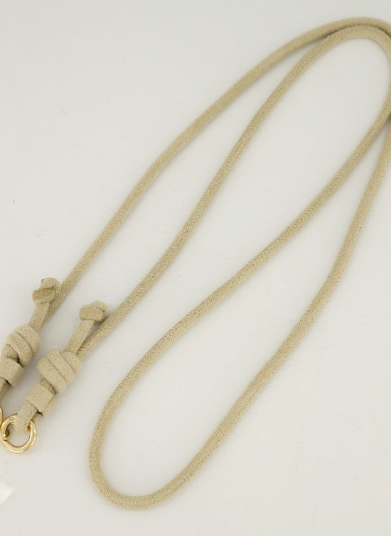 Detail van de stevige sluiting en het zachte materiaal van het beige crossbody telefoonkoord.