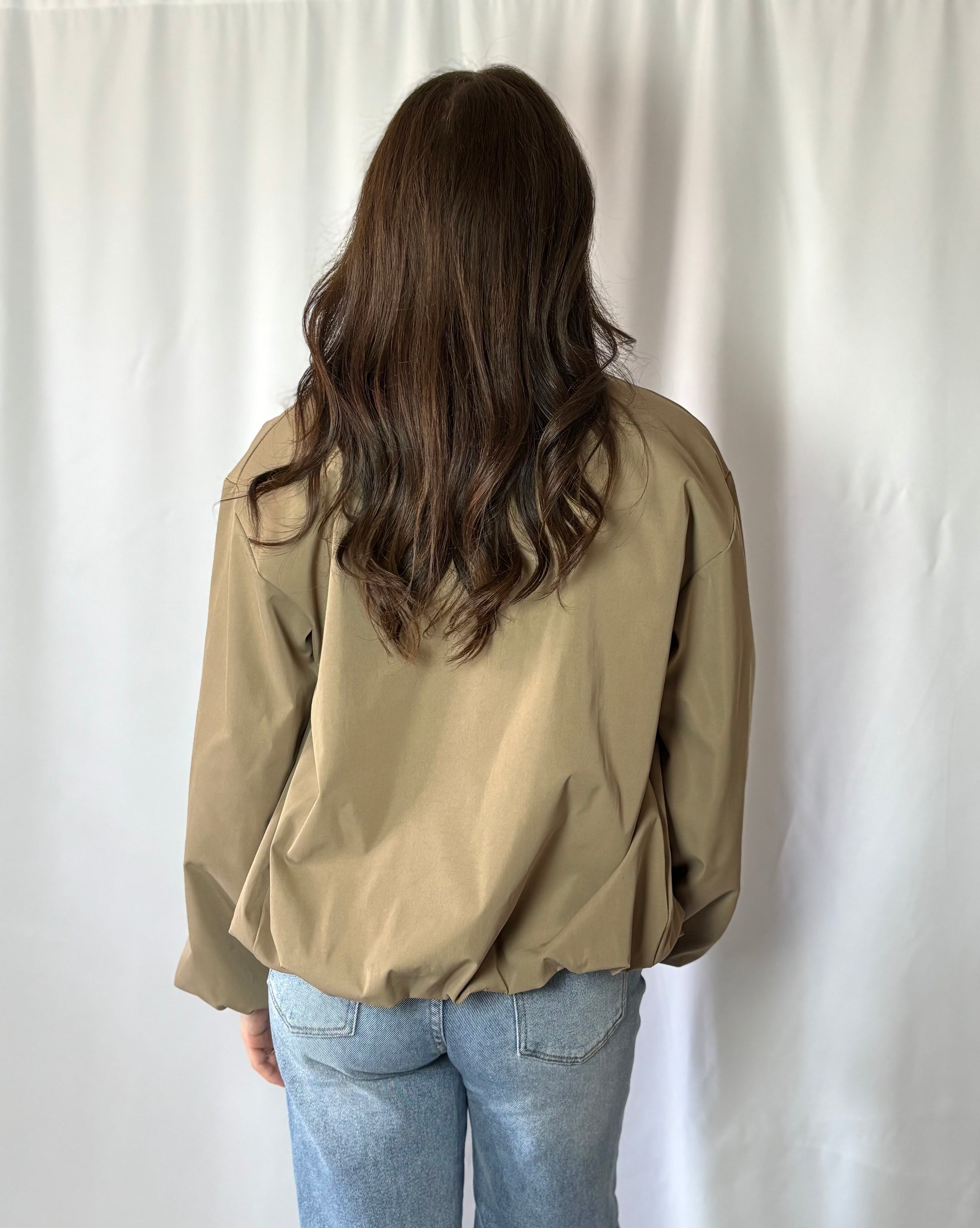 Achterkant van de balloon fit jas in beige.