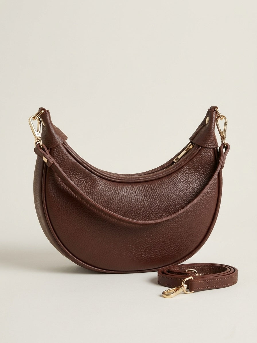 Bruine leren Emma Bag met gold hardware in minimalistische beige studio setting, front view.