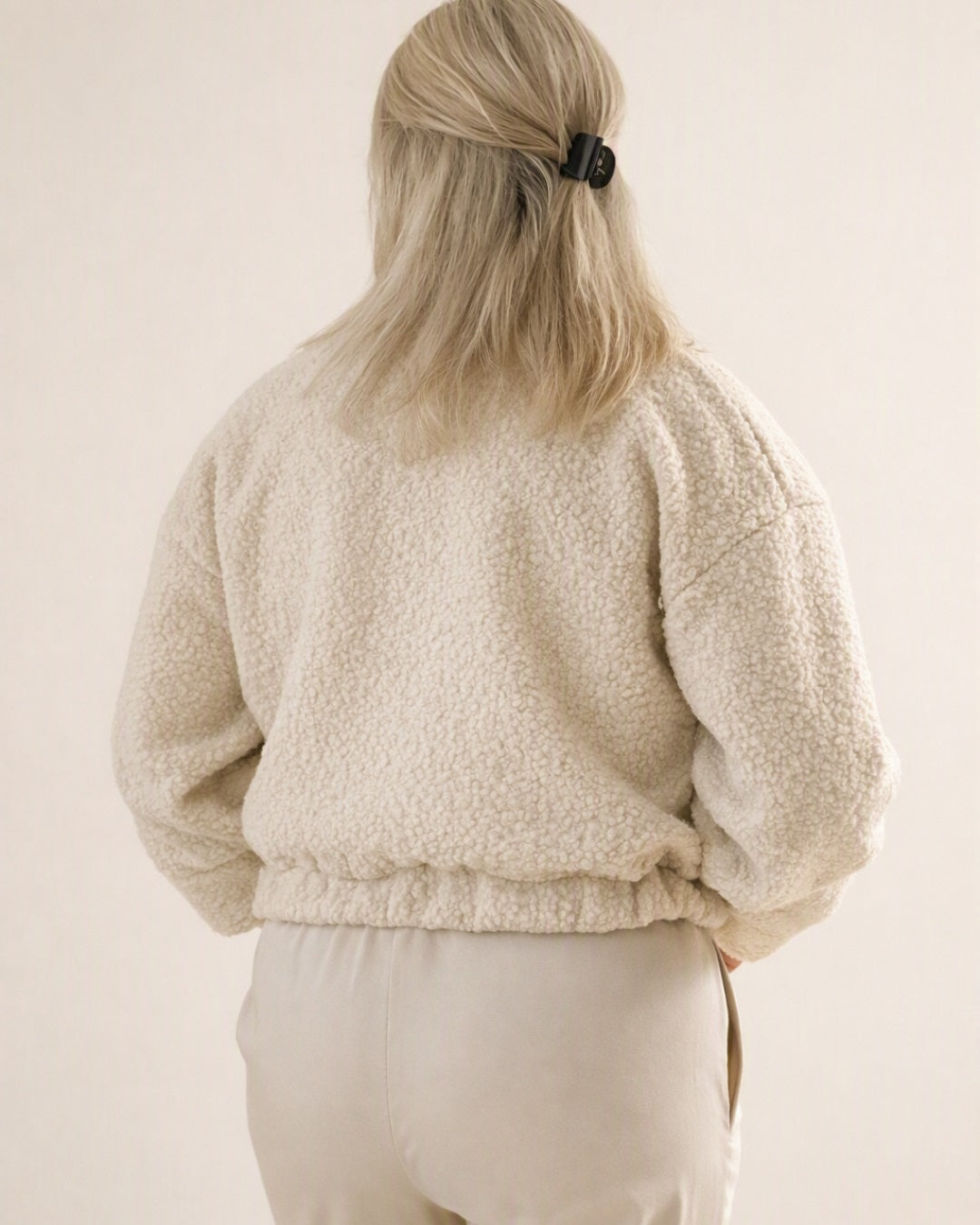 Achterkant productfoto van de zachte, warme teddy-stof en de afwerking van de beige damestrenchcoat of bomber van Myjewellen.