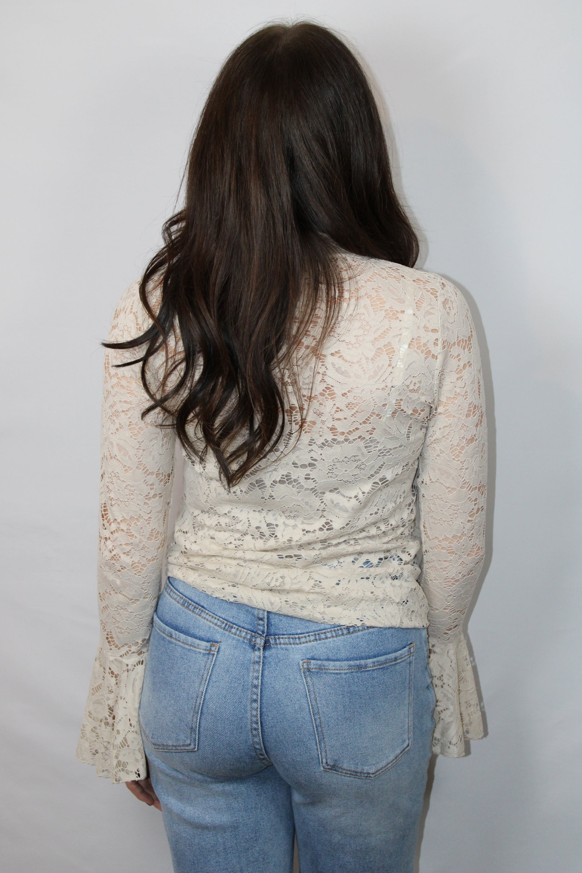 Achterkant productfoto van de verfijnde kanten structuur en de zachte mesh stof van de beige dames top Lana.