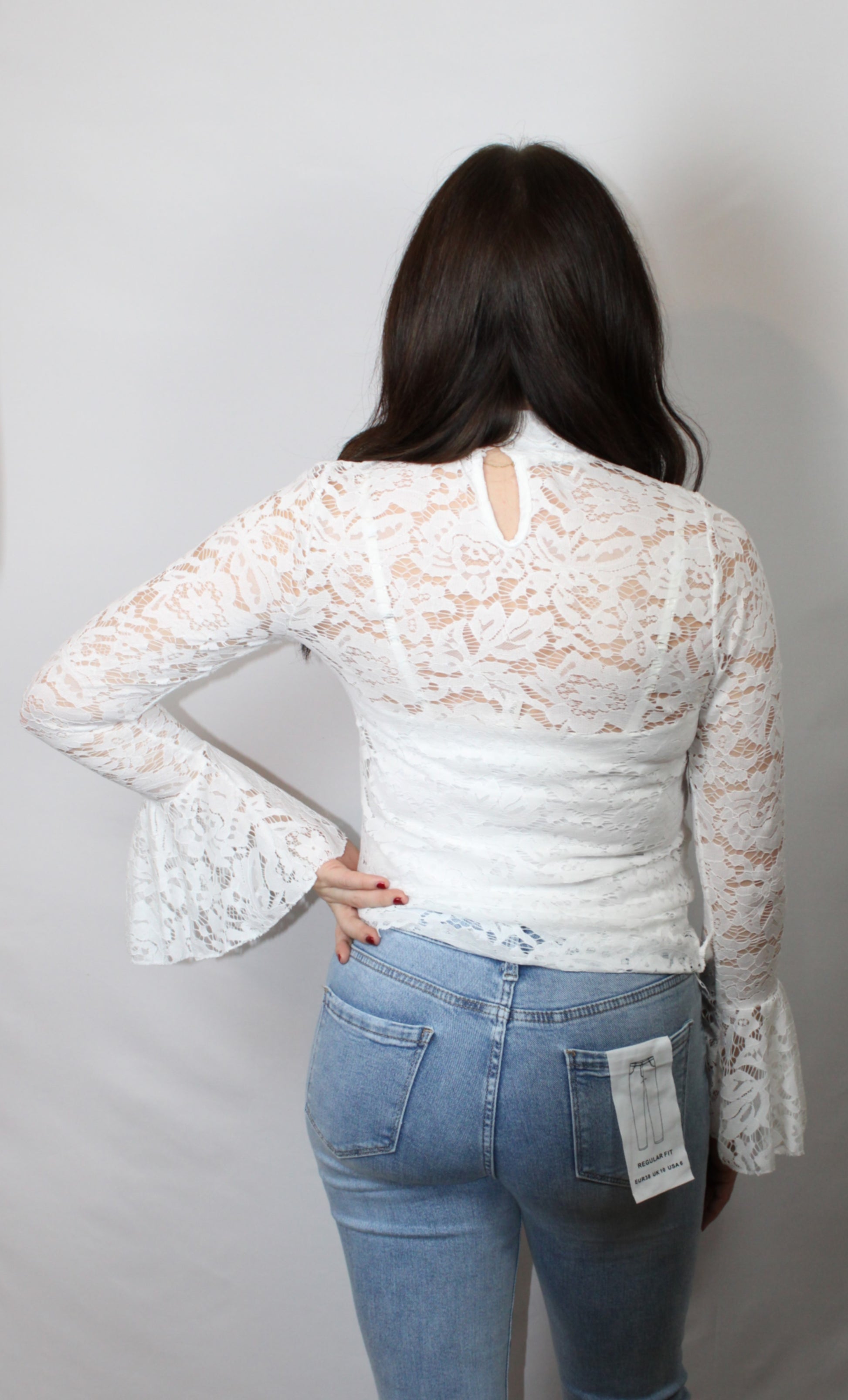 Achterkant productfoto van de verfijnde kanten structuur en de zachte mesh stof van de witte dames top Lana.