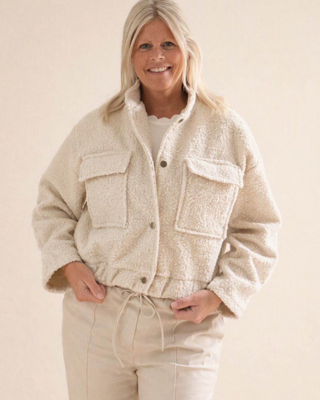 Beige teddy bomber voor dames van Myjewellen: een warme, zachte teddy jas in een trendy bomber-design met zakken.