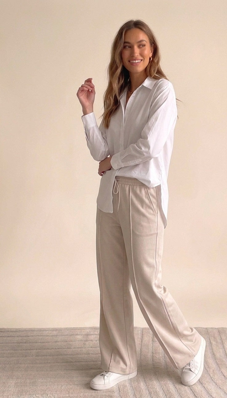 Gedetailleerde productfoto van de achterkant van de oversized witte blouse Mara, met een flatterende langere valling.