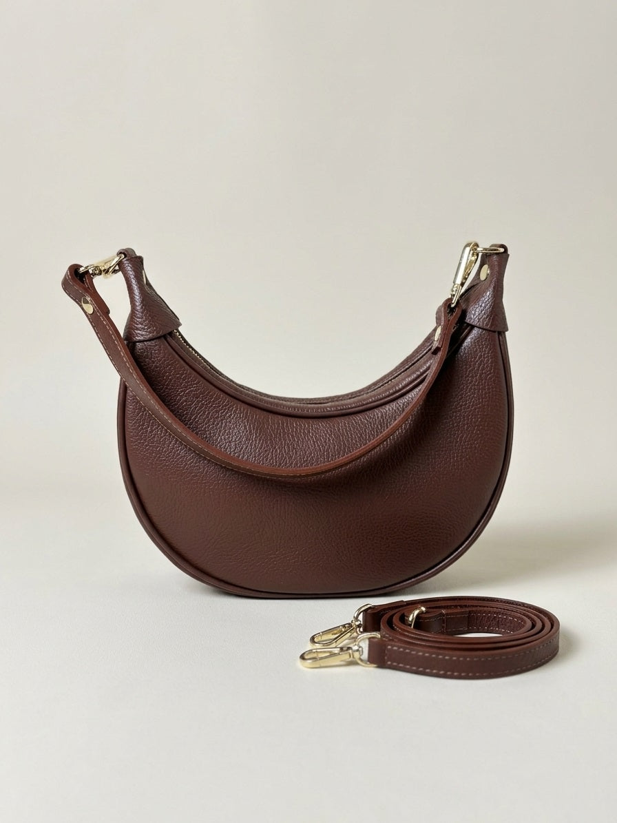 Bruine leren Emma Bag met losse schouderband en gold clasps, clean neutral luxe studio setting.
