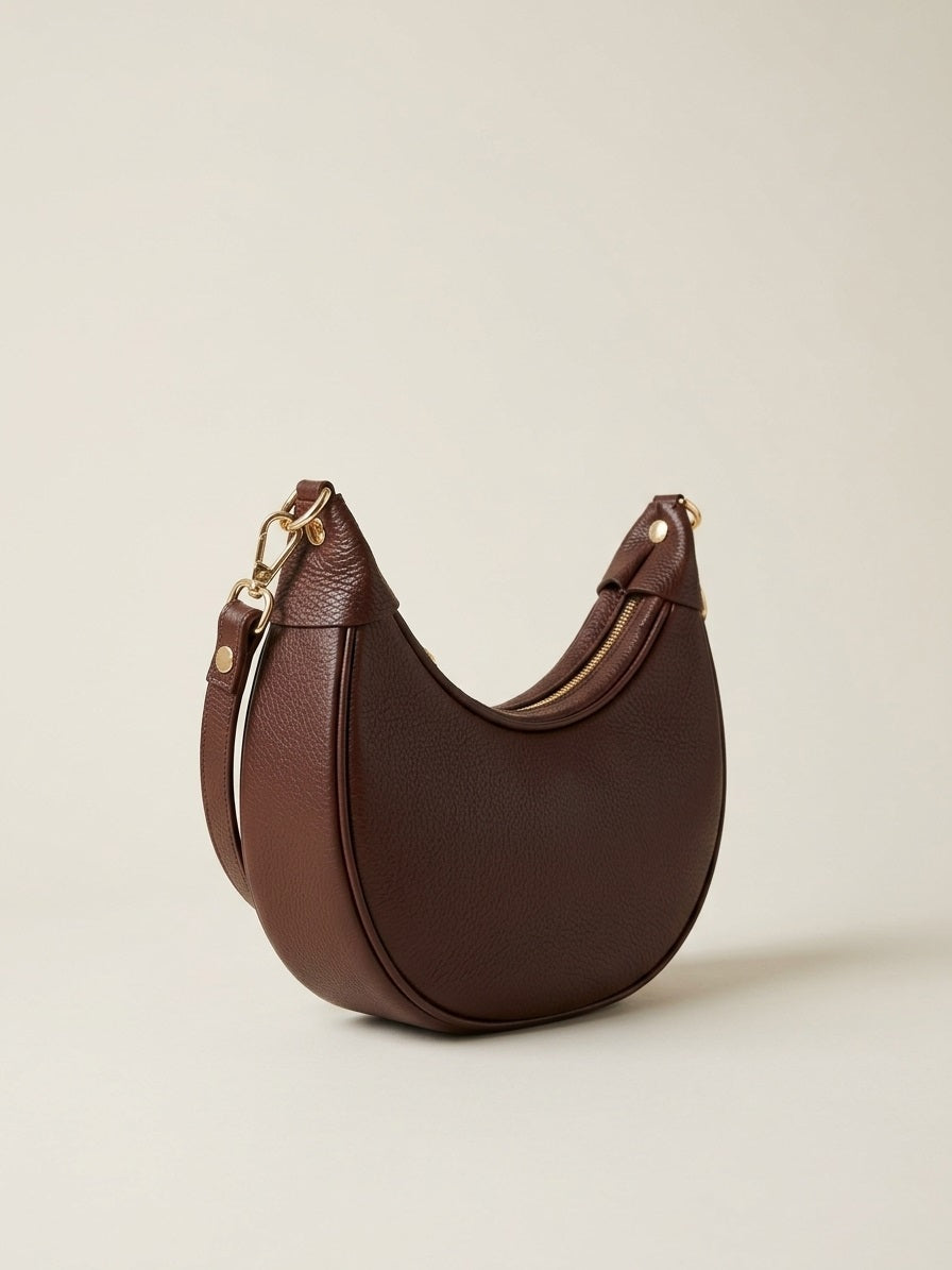 Detail van de goudkleurige hardware en de verstelbare schouderriem van de bruine Emma Bag