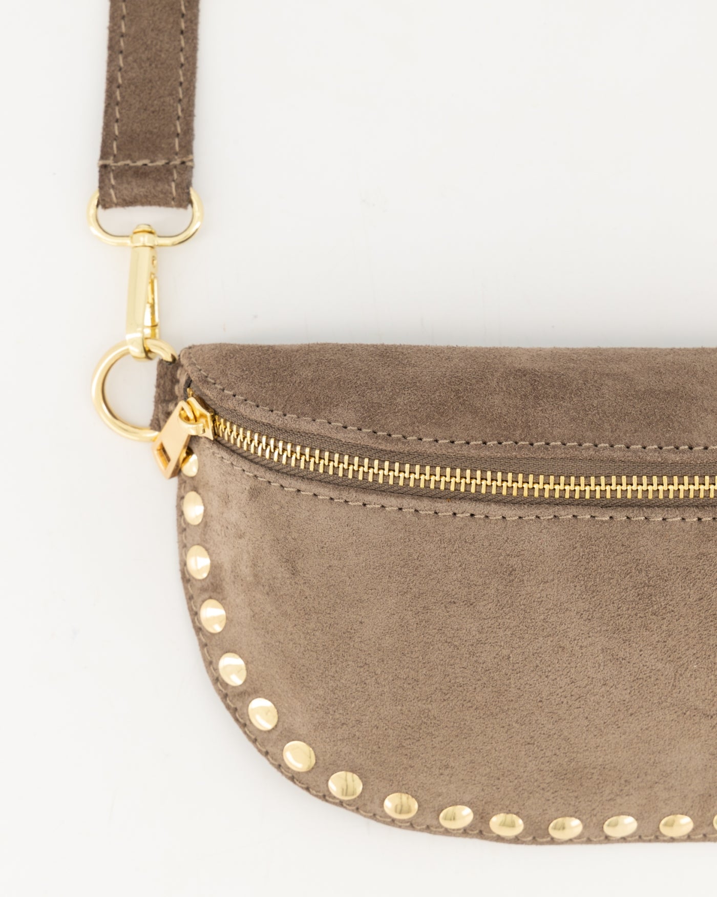 Zijaanzicht van taupe suède small bag met half‑moon vorm, gold studs en verstelbare strap.