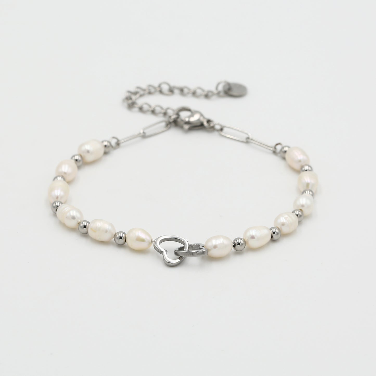 Detail van de zilveren armband met witte parels en een handige karabijnsluiting met verlengkettinkje.
