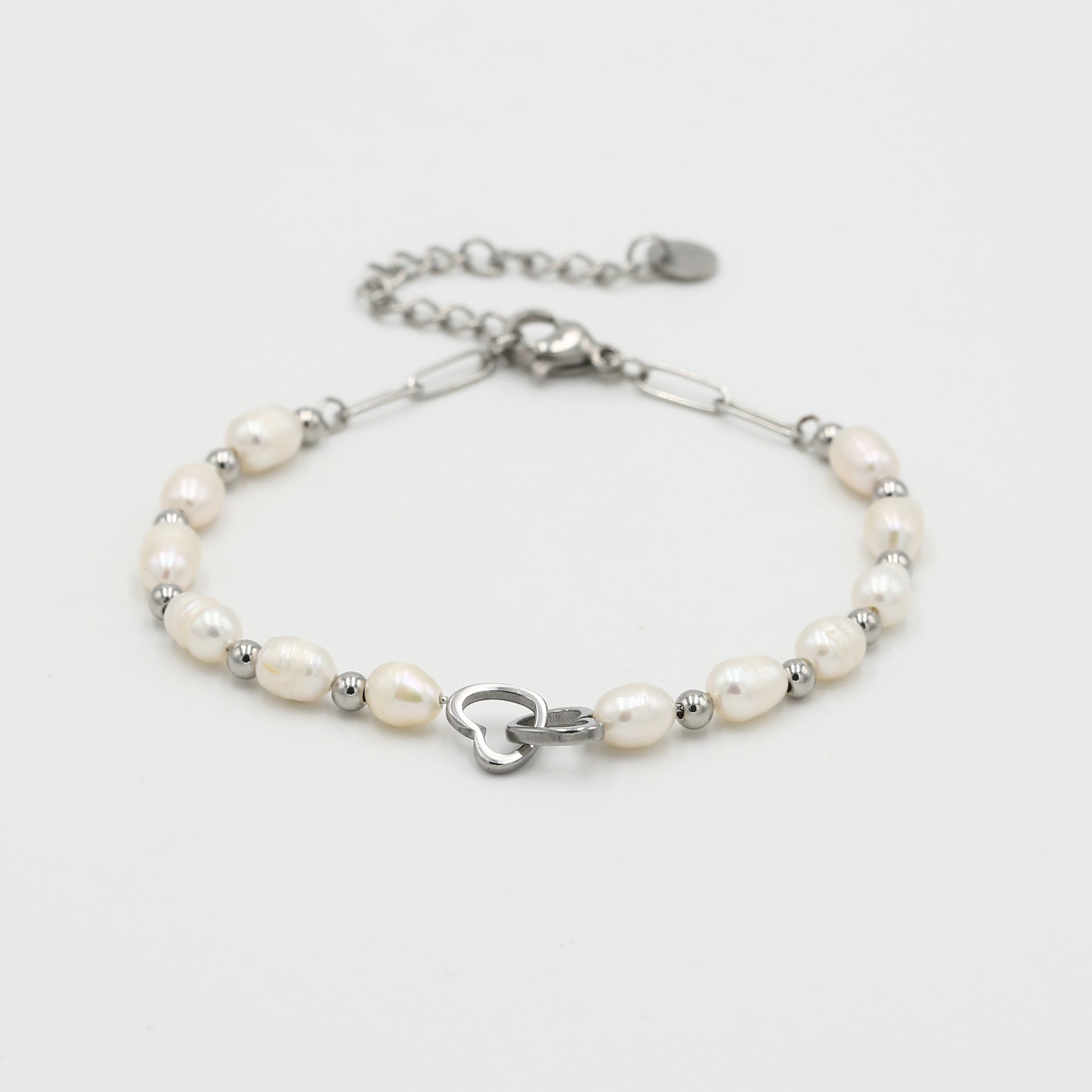 Detail van de zilveren armband met witte parels en een handige karabijnsluiting met verlengkettinkje.