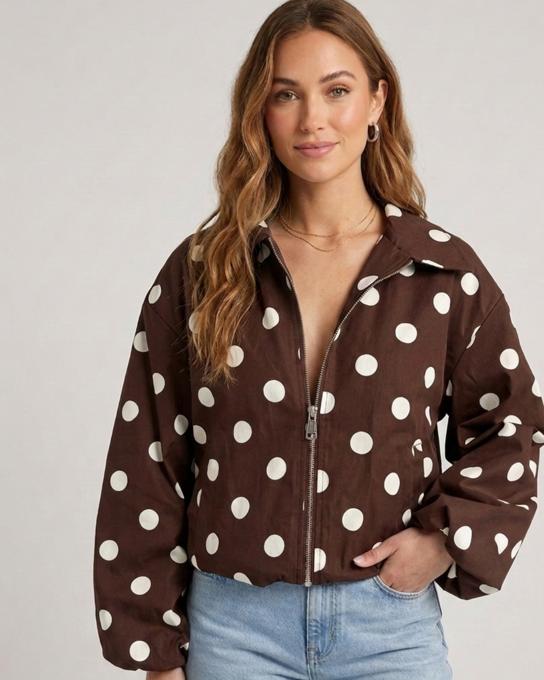 Model draagt het Polka Dot Jacket Brown van Myjewellen, een trendy bruine dames jas met witte stippen gecombineerd met een denim jeans