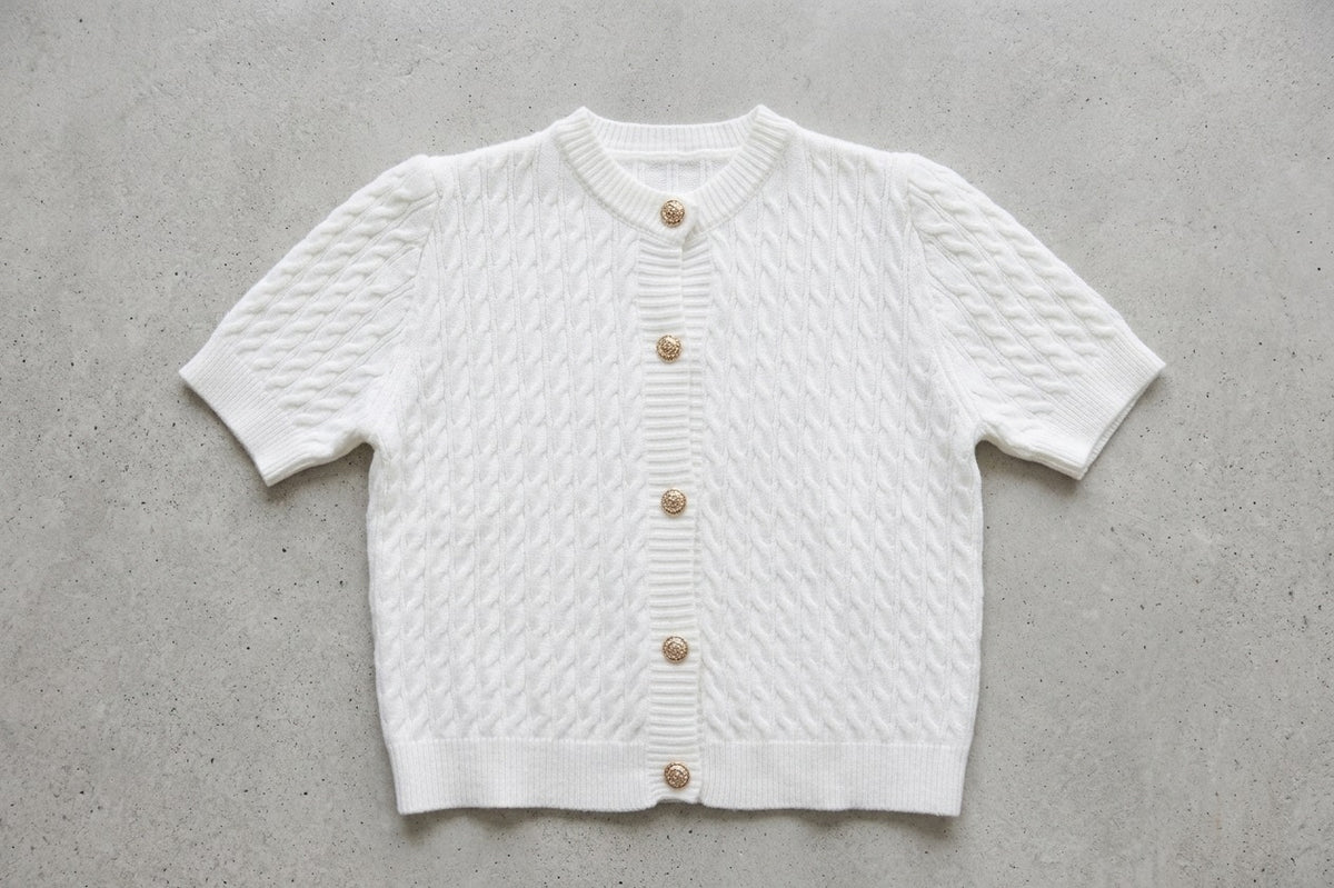 detail foto Witte knit cardigan met kabelstructuur en gouden knopen.