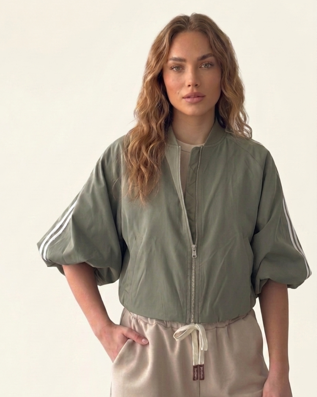 Model draage een sage green zip up track jacket