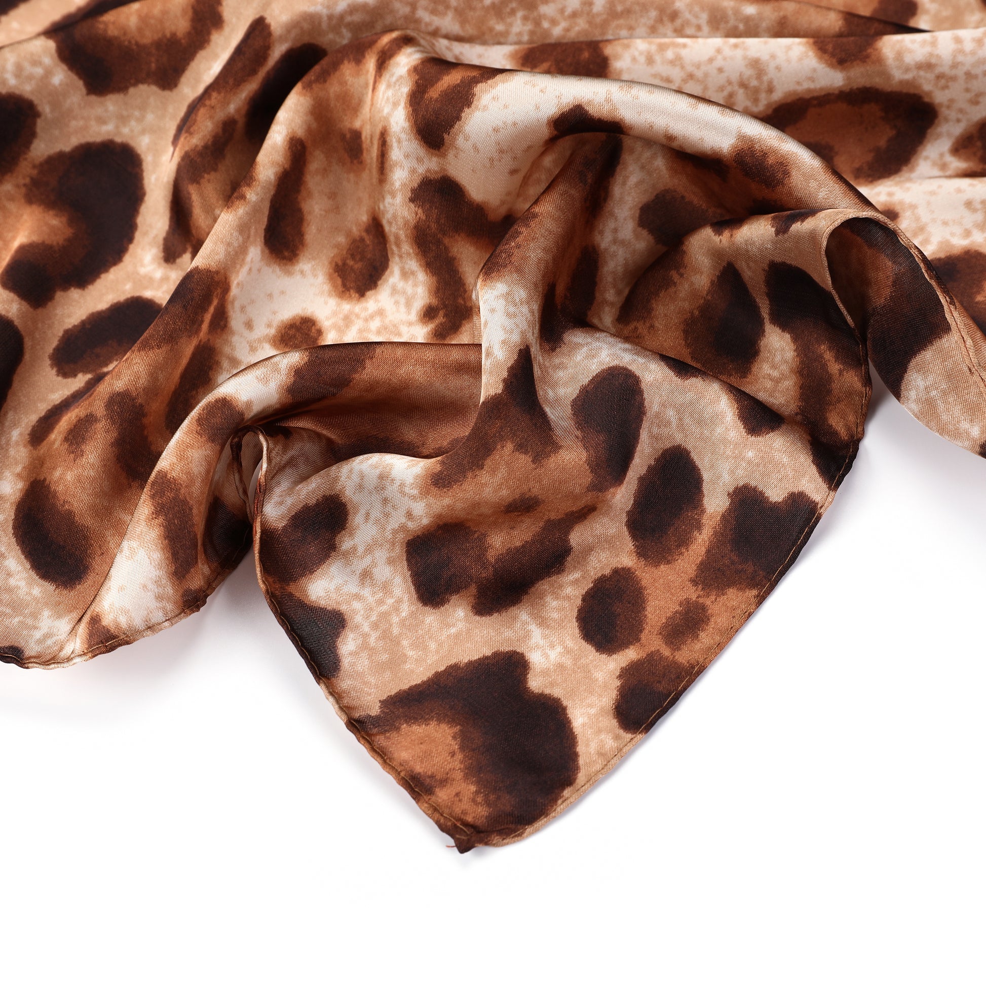 Detail van de gladde, zijdezachte stof met luipaardprint van de camelkleurige dames bandana.