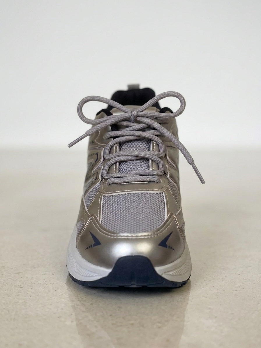 Bovenaanzicht van zilveren sneaker met grijze veters en mesh bovenwerk.