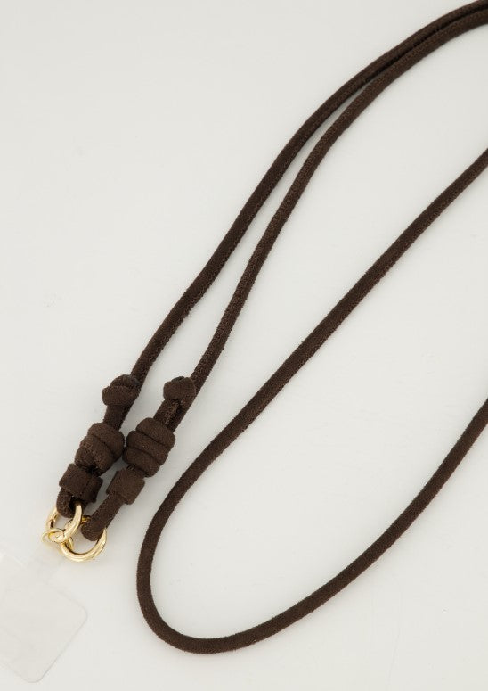Detail van de stevige sluiting en het zachte materiaal van het bruine crossbody telefoonkoord.
