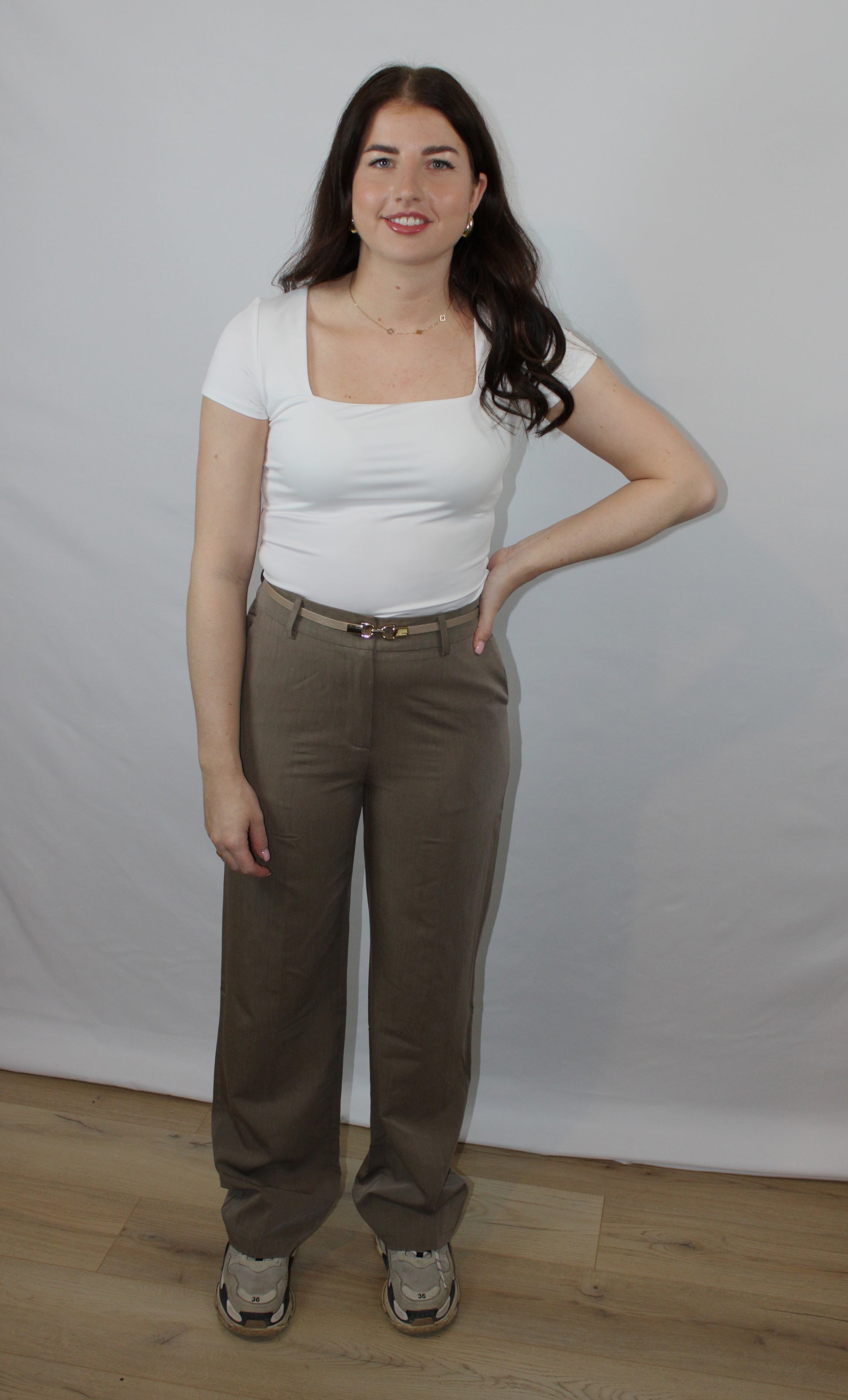 Wit dames T-shirt met vierkante hals en korte mouwen, gedragen door een model op een pantalon.