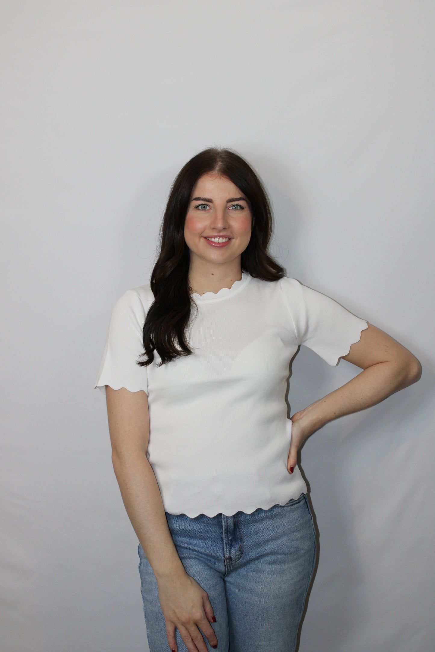 Close-up van de speelse golfranden op de mouw van het witte Myjewellen T-shirt.