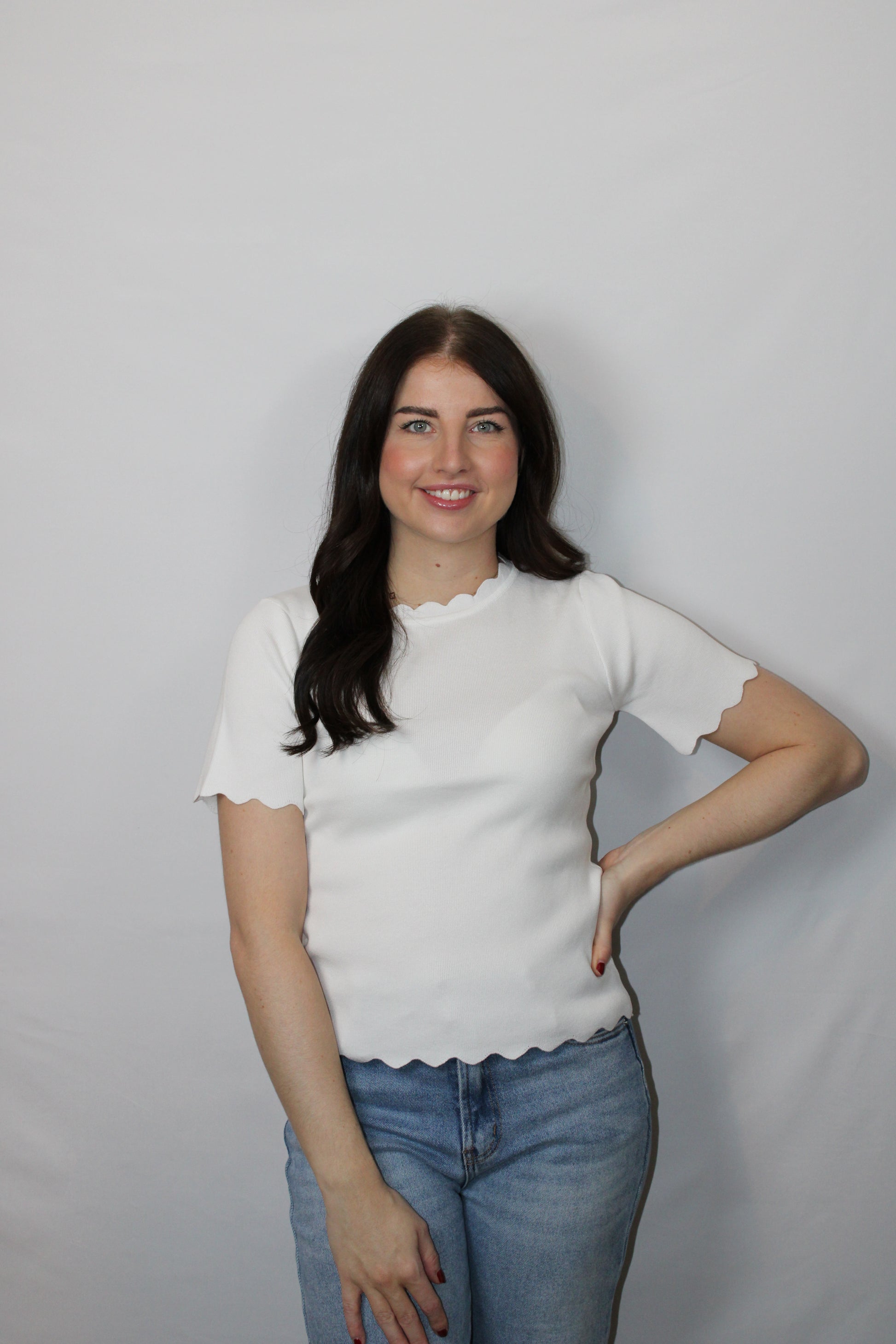 Close-up van de speelse golfranden op de mouw van het witte Myjewellen T-shirt.